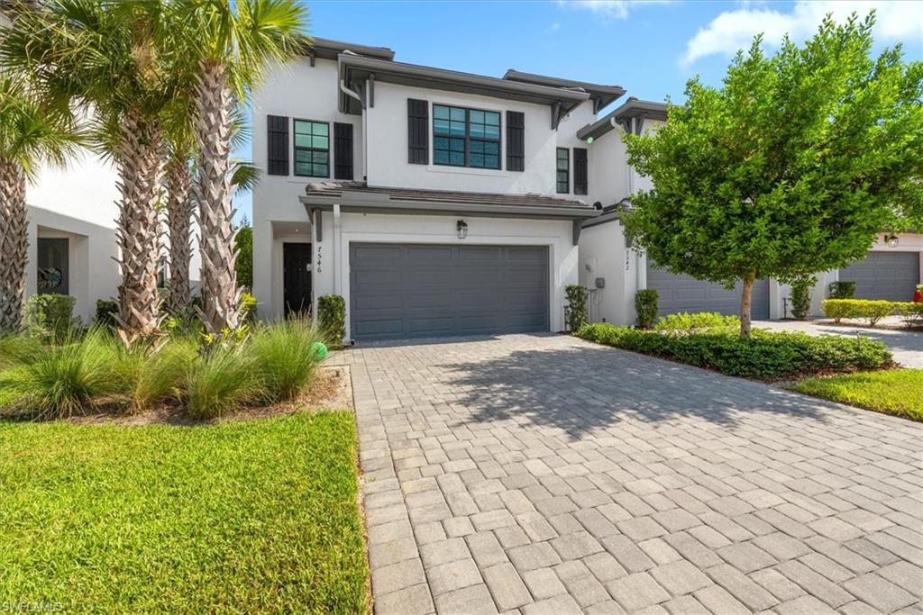 7546 Rockefeller Drive Naples, FL 34119 - Photo 3 of 31 View of front of house with stucco siding, an attached garage, and decorative driveway
