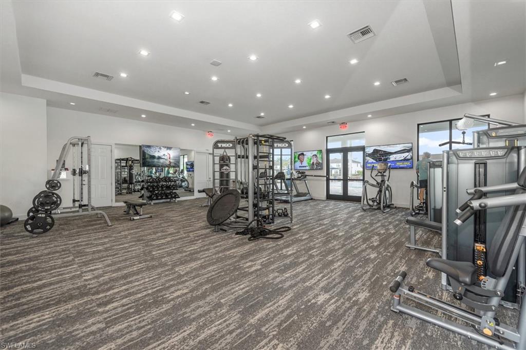 7546 Rockefeller Drive Naples, FL 34119 - Photo 30 of 31 Gym featuring a tray ceiling, carpet flooring, recessed lighting, and french doors