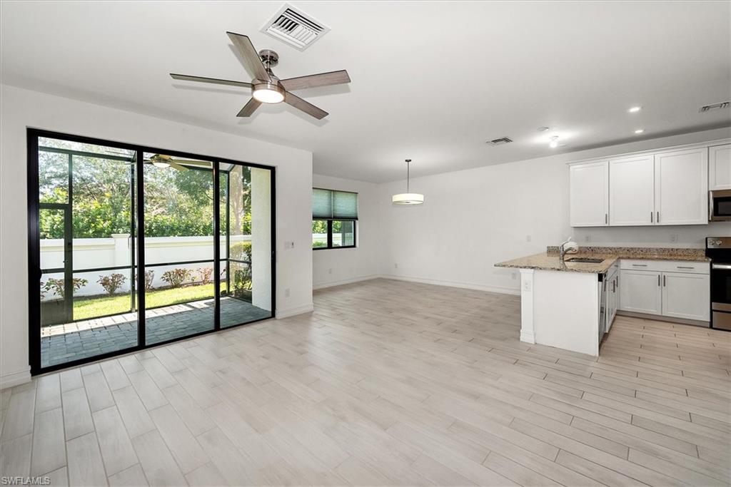 7546 Rockefeller Drive Naples, FL 34119 - Photo 5 of 31 Kitchen featuring a peninsula, white cabinetry, stainless steel appliances, light wood-style flooring, and recessed lighting