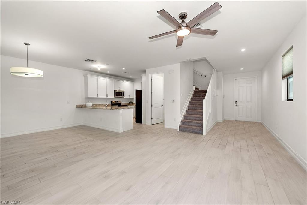 7546 Rockefeller Drive Naples, FL 34119 - Photo 8 of 31 Unfurnished living room with a ceiling fan, stairs, light wood-type flooring, and recessed lighting