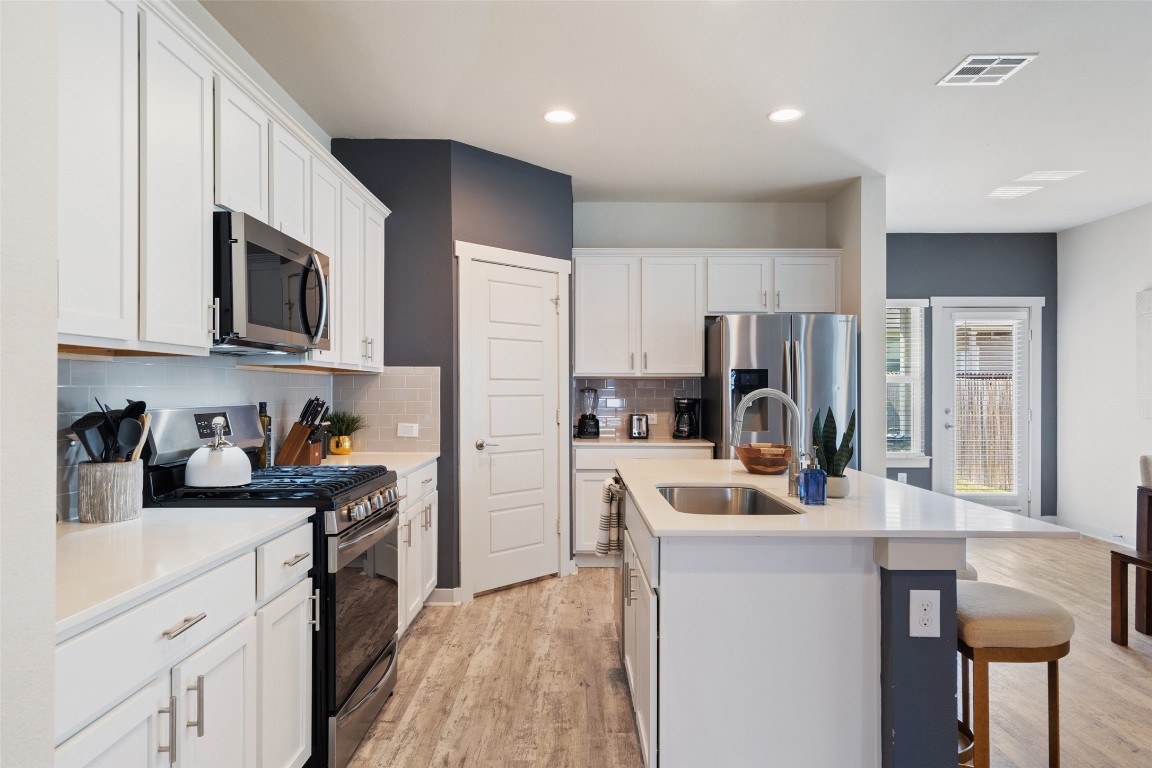 8313 City Top Boulevard Austin, TX 78724 - Photo 11 of 37 a kitchen with refrigerator a microwave a sink and cabinets