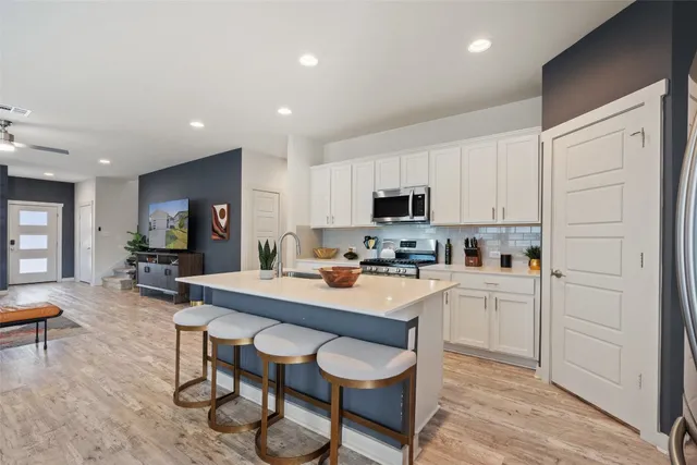 a kitchen with appliances a table and chairs in it