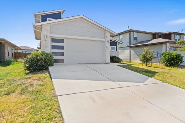 a front view of a house with a yard and potted plants