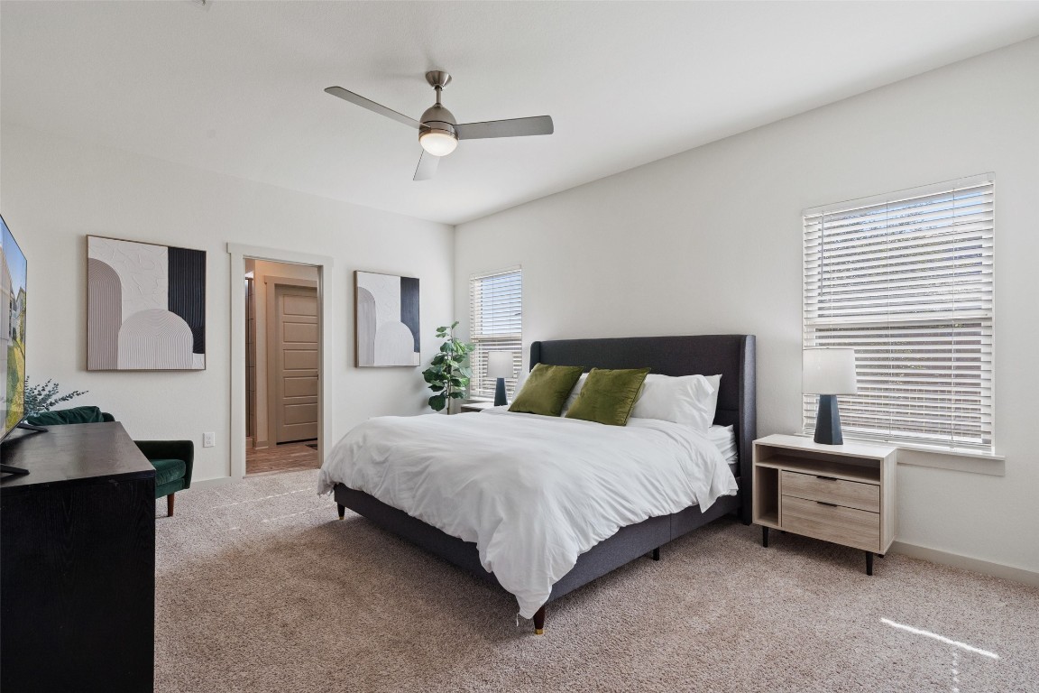 8313 City Top Boulevard Austin, TX 78724 - Photo 23 of 37 a spacious bedroom with a bed and a chandelier