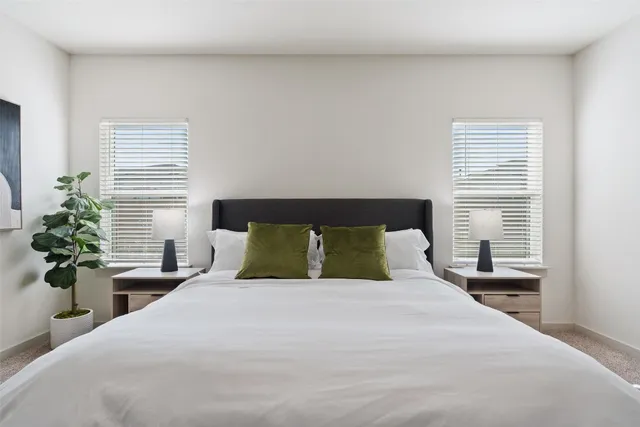 a bedroom with a large bed and a potted plant