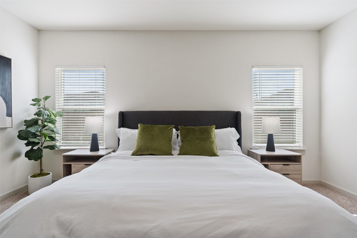 8313 City Top Boulevard Austin, TX 78724 - Photo 24 of 37 a bedroom with a large bed and a potted plant