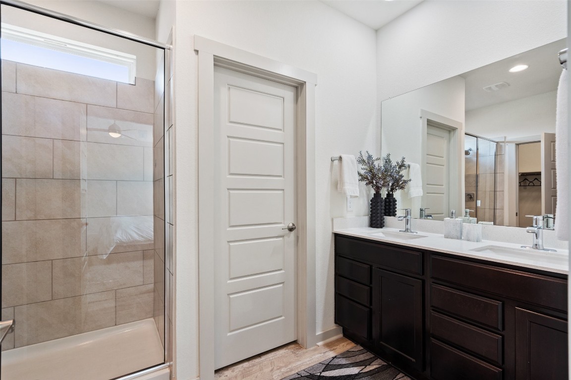 8313 City Top Boulevard Austin, TX 78724 - Photo 25 of 37 a bathroom with a double vanity sink a mirror and a shower