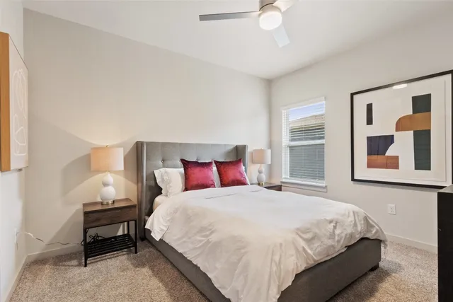 a bedroom with a bed lamp and a potted plant