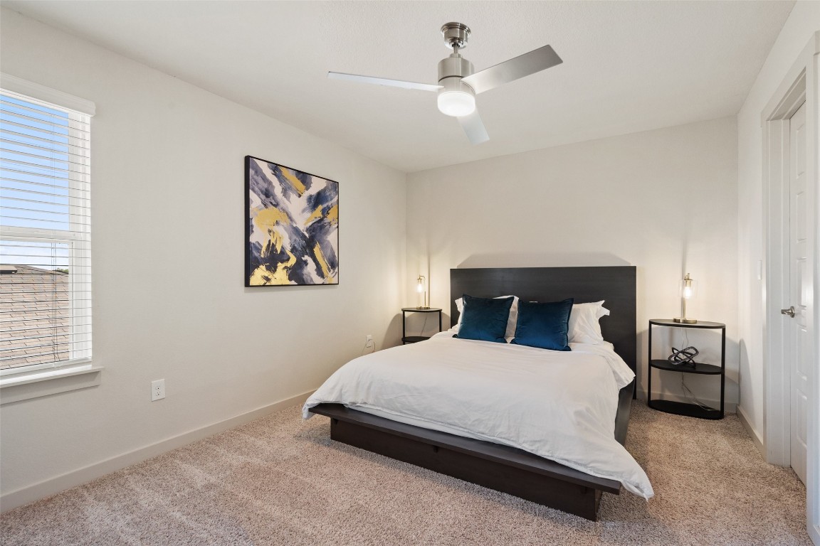 8313 City Top Boulevard Austin, TX 78724 - Photo 29 of 37 a bedroom with a large bed and a chandelier