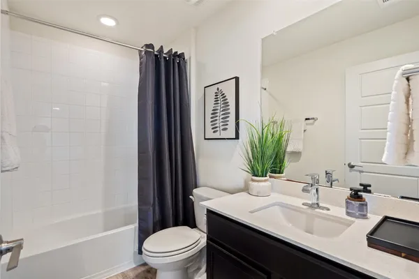 a bathroom with a sink a toilet a tub and shower