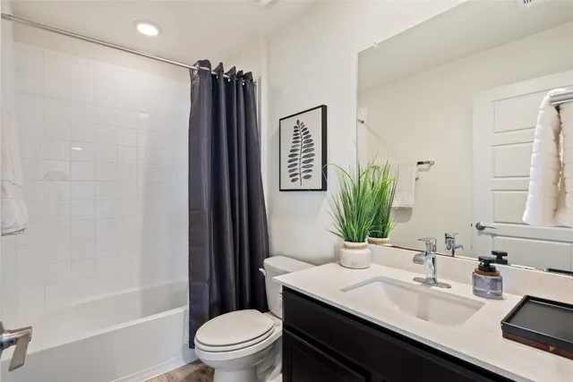 a bathroom with a sink a toilet a tub and shower