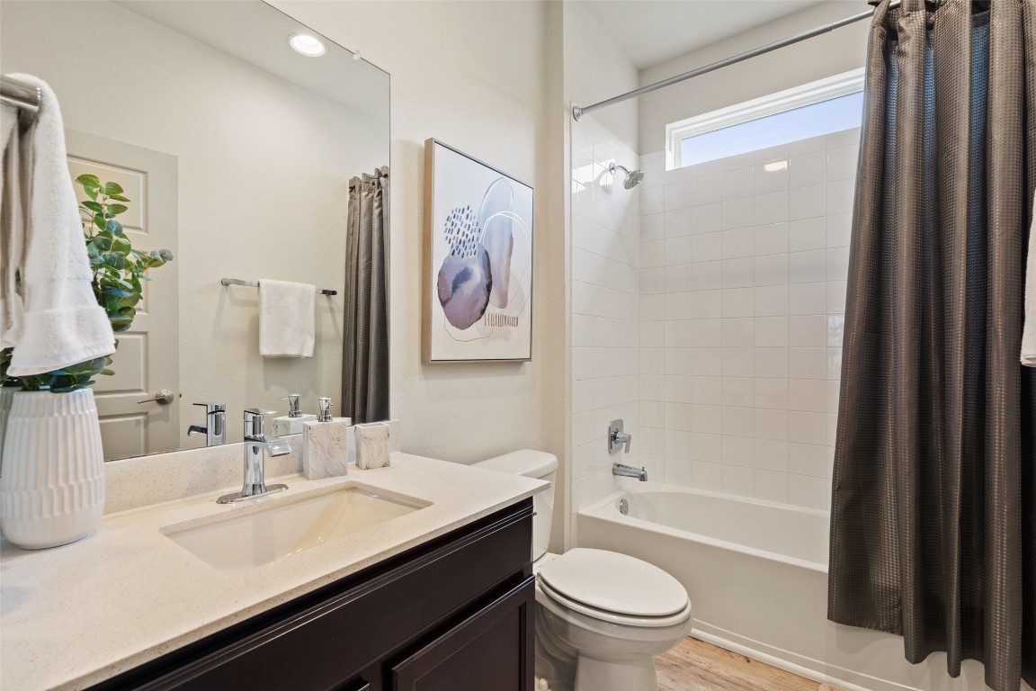 8313 City Top Boulevard Austin, TX 78724 - Photo 32 of 37 a bathroom with a granite countertop sink toilet and shower