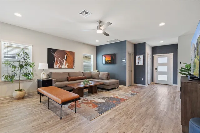 a living room with furniture and a wooden floor