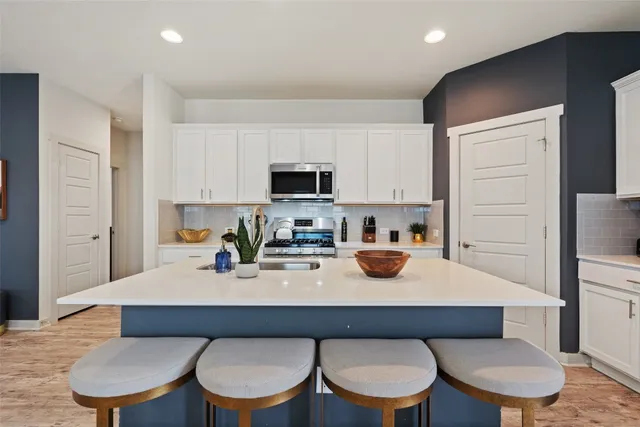 a kitchen with a sink a stove and chairs