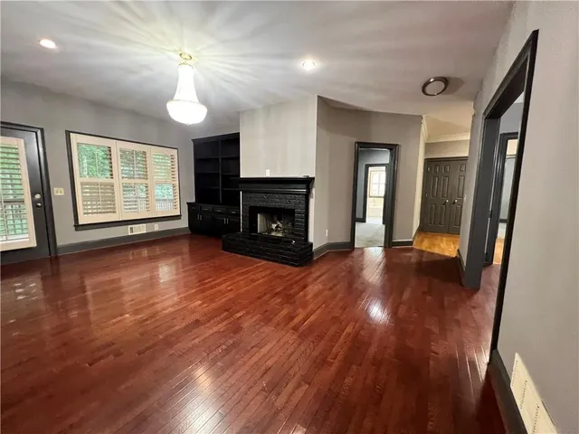 a living room with hard wood floors and a fireplace