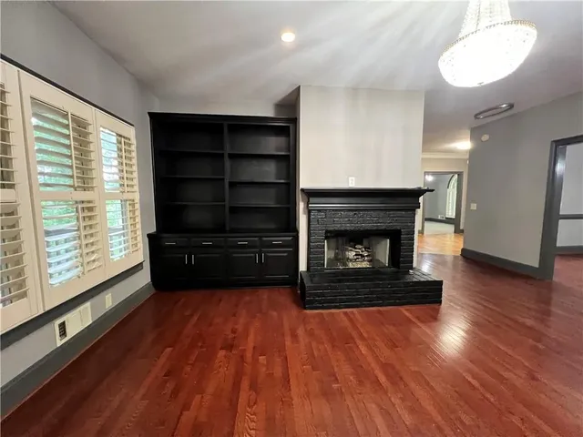 a view of a livingroom with a furniture a fireplace and a window