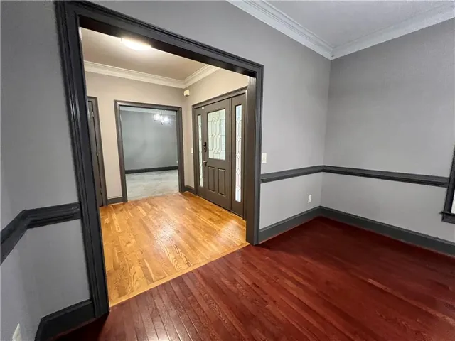 an empty room with windows and chandelier