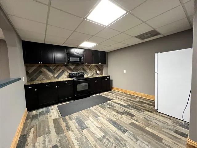 a view of a refrigerator in kitchen and an empty room