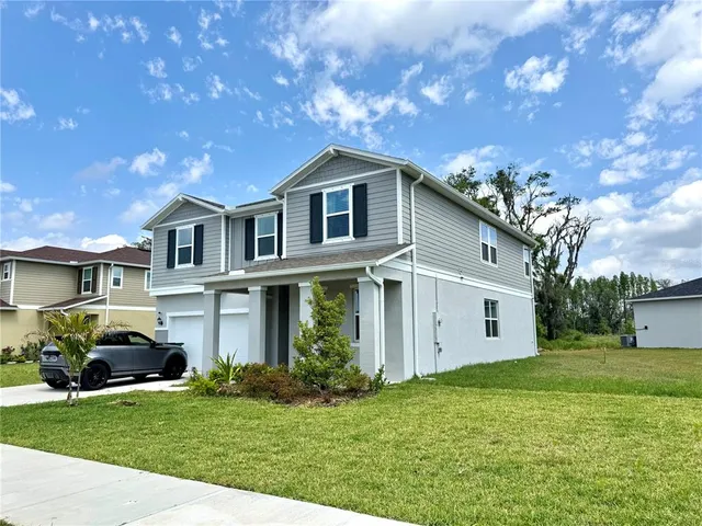 a front view of a house with a garden and yard