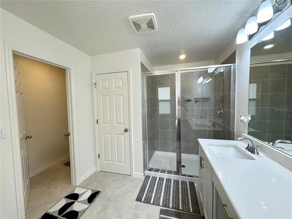 a bathroom with a sink a toilet a mirror and shower