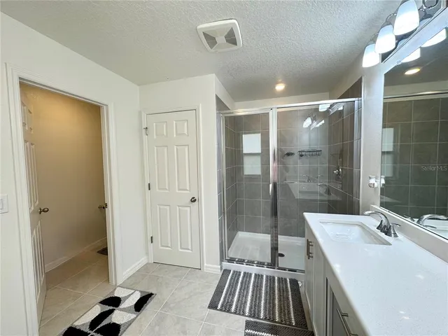 a bathroom with a sink a toilet a mirror and shower