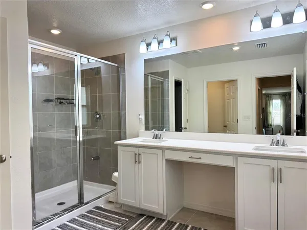 a bathroom with a shower sink and mirror