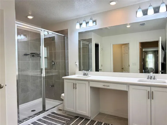 a bathroom with a shower sink and mirror