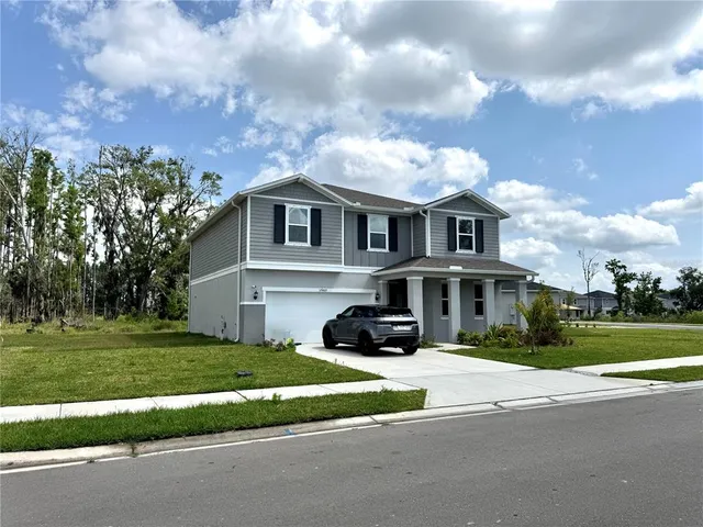 a front view of a house with a garden and trees