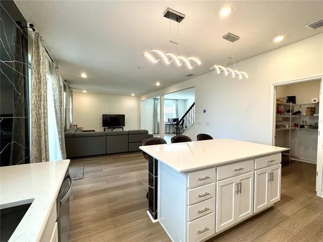 a kitchen with kitchen island a sink stainless steel appliances and cabinets