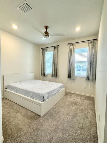 a spacious bedroom with a bed and a large window