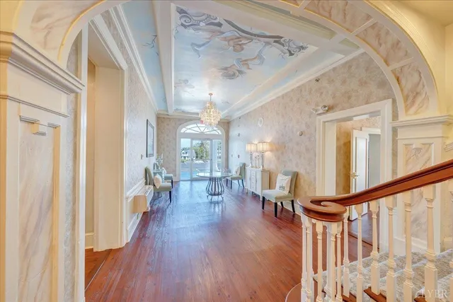 a view of a dining room with furniture a chandelier and wooden floor