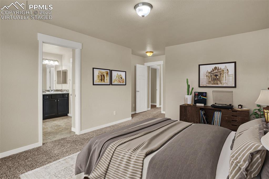 6750 Alliance Loop Colorado Springs, CO 80925 - Photo 19 of 32 a bedroom with a bed and a view of kitchen
