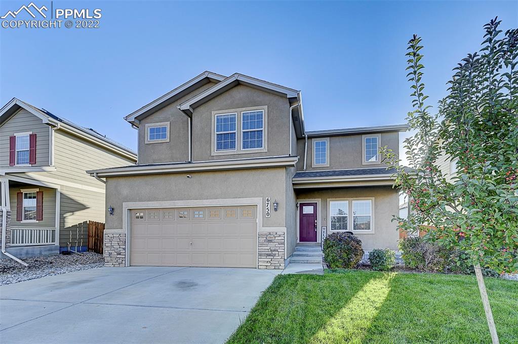 6750 Alliance Loop Colorado Springs, CO 80925 - Photo 2 of 32 a front view of a house with a yard and garage