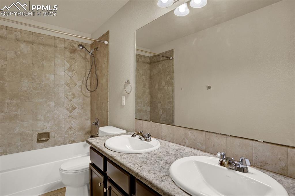 6750 Alliance Loop Colorado Springs, CO 80925 - Photo 26 of 32 a bathroom with a granite countertop sink toilet and shower