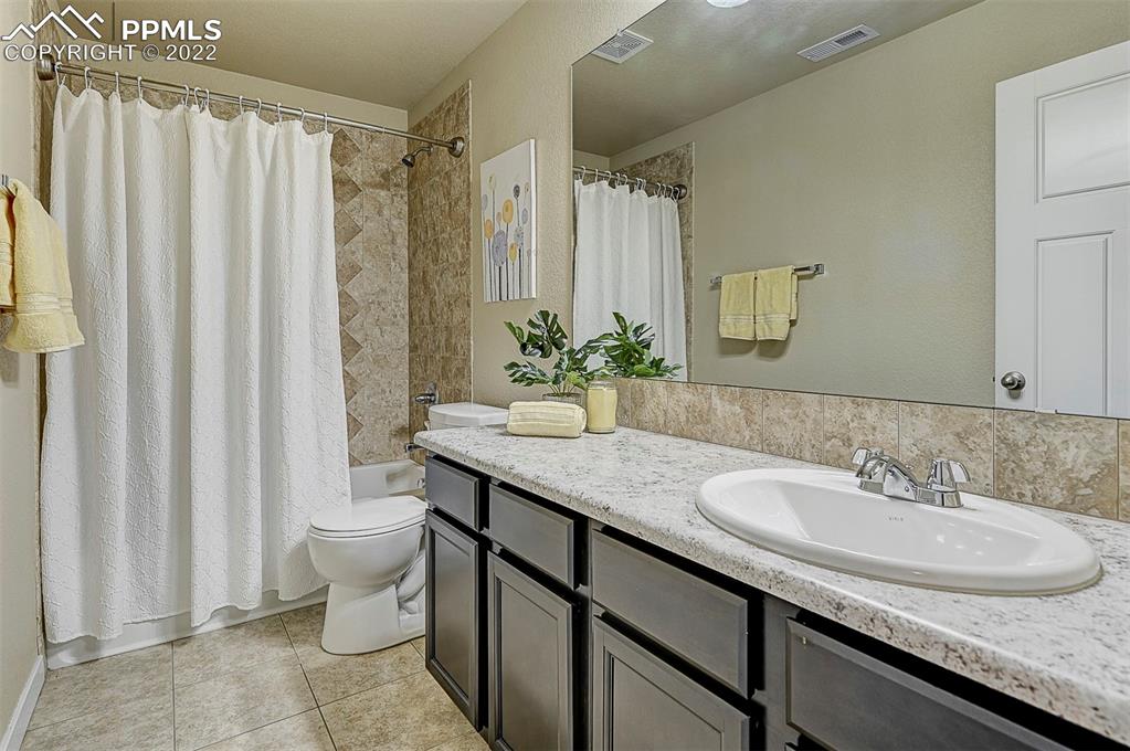 6750 Alliance Loop Colorado Springs, CO 80925 - Photo 30 of 32 a bathroom with a granite countertop sink and a mirror
