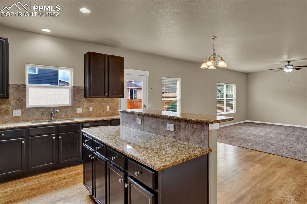 6750 Alliance Loop Colorado Springs, CO 80925 - Photo 8 of 32 a kitchen with granite countertop a sink a center island and cabinets