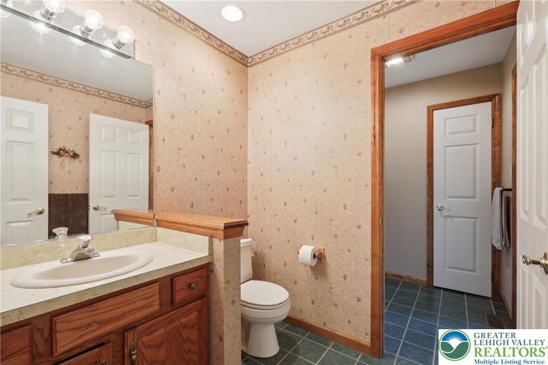 1705 Deer Path Road Easton, PA 18040 - Photo 19 of 42 a bathroom with a granite countertop toilet a sink and a mirror