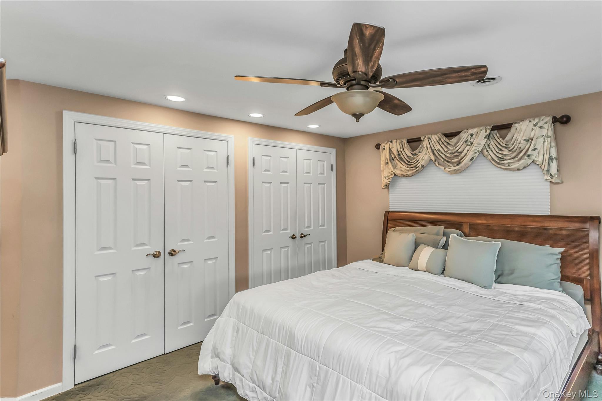 57 Joyce Road Plainview, NY 11803 - Photo 12 of 20 a bedroom with a large bed and a chandelier