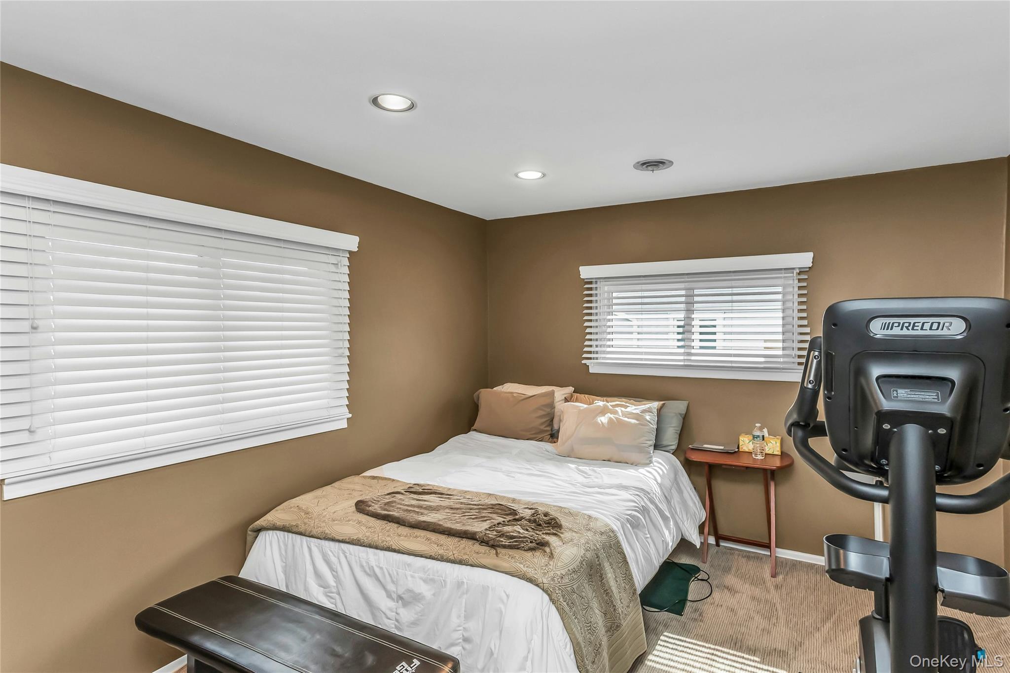 57 Joyce Road Plainview, NY 11803 - Photo 14 of 20 a bedroom with a bed a dresser next to a window
