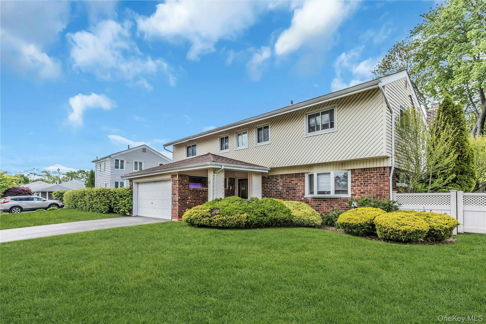57 Joyce Road Plainview, NY 11803 - Photo 2 of 20 a front view of house with yard and green space
