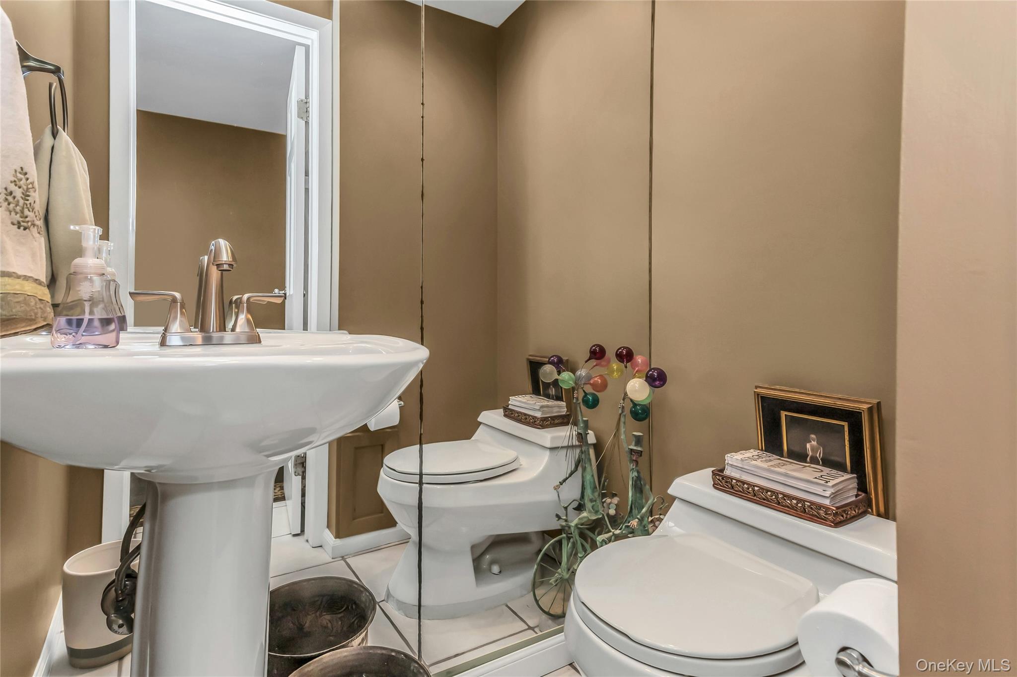 57 Joyce Road Plainview, NY 11803 - Photo 5 of 20 a bathroom with a sink a toilet and mirror