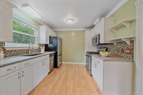 a kitchen with stainless steel appliances granite countertop a stove a sink and a refrigerator