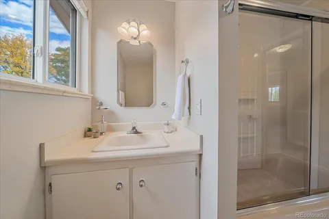 a bathroom with a sink a mirror and a shower