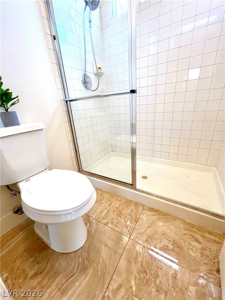 9708 Ridge Creek Place Las Vegas, NV 89134 - Photo 26 of 34 A well-maintained shower with pristine white subway tile and a sleek glass enclosure.