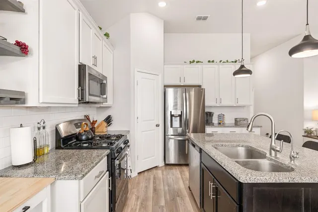 a kitchen with stainless steel appliances granite countertop a sink stove and refrigerator
