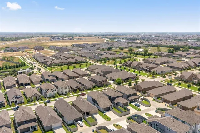 an aerial view of a city with lots of residential buildings and mountain view in back