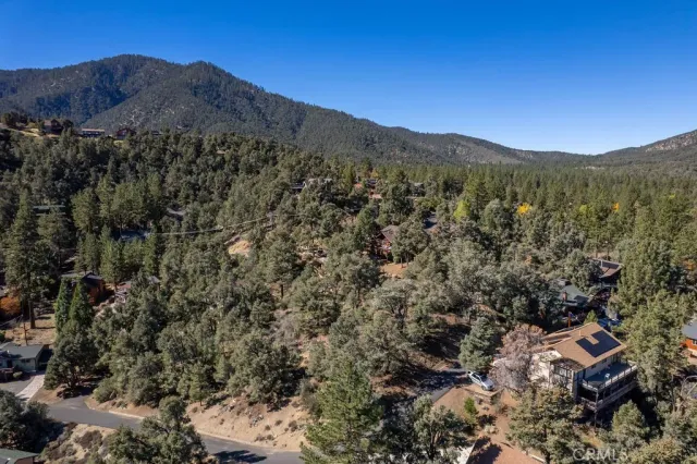 an aerial view of residential house with parking and trees