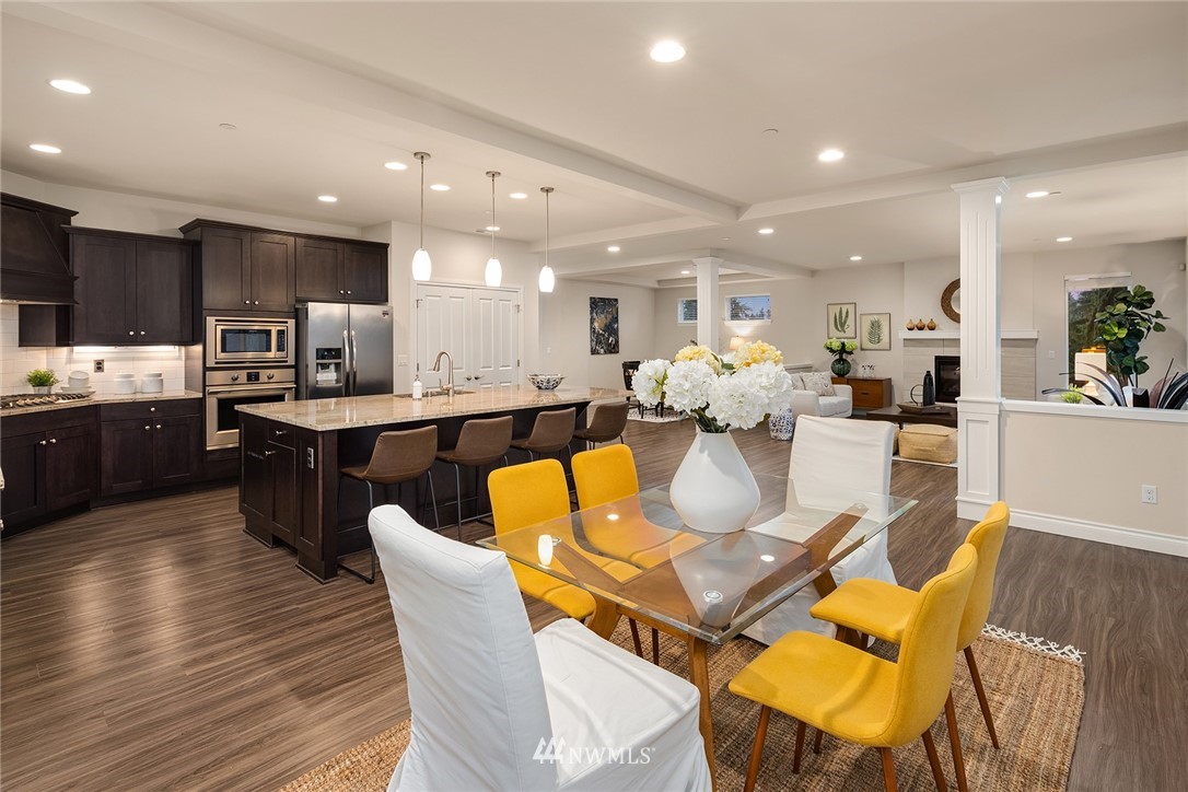 307 221st Place Southwest Bothell, WA 98021 - Photo 11 of 29 a dining room with stainless steel appliances kitchen island granite countertop a dining table chairs and view kitchen