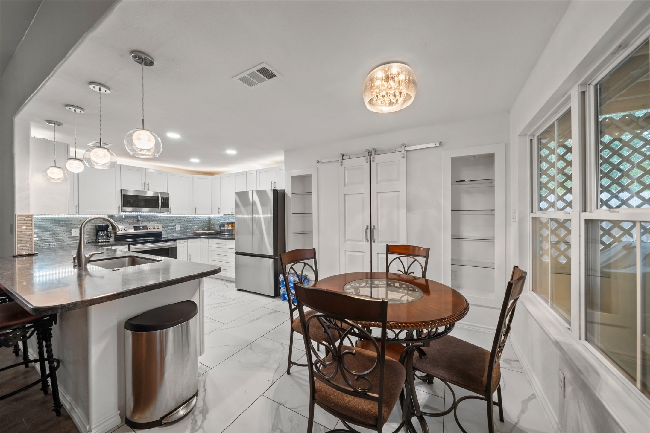 25434 Cedar Lane Splendora, TX 77372 - Photo 13 of 29 a kitchen with stainless steel appliances a dining table chairs and a refrigerator