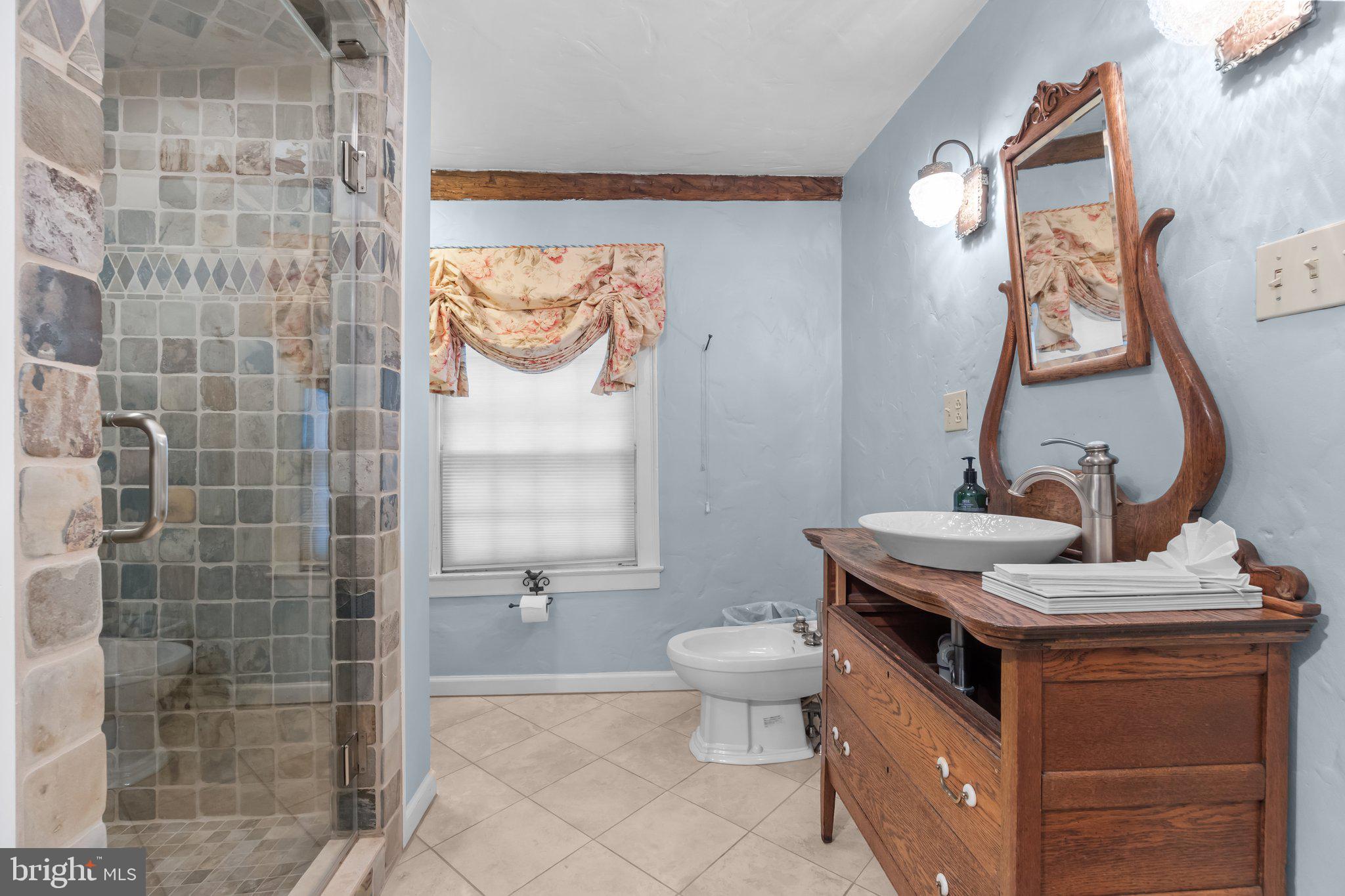111 South State Street Newtown, PA 18940 - Photo 19 of 37 a bathroom with a granite countertop sink a toilet and a mirror